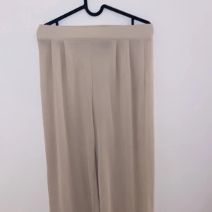 Beige vida byxor - Säljer ett par snygga beige byxor i loose fit. De är vida och perfekta för en avslappnad stil. Byxorna har några små fläckar men är annars i bra skick. Perfekta för både vardag och fest!