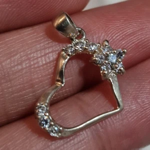 Hjärtaformad hängsmycke med stenar äkta 925 silver  - Säljer ett superfint hängsmycke i form av ett hjärta. Det är dekorerat med gnistrande stenar som ger en lyxig känsla. Perfekt för att piffa upp vilken outfit som helst! 💎