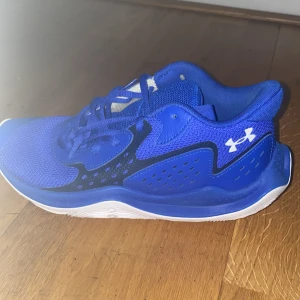 Blå sneakers från Under Armour     350kr för ett bra pris dom e knappt använda - Säljer ett par snygga blå sneakers från Under Armour. De har en sportig design med snörning och en vit sula som ger bra grepp. Perfekta för träning eller vardagsbruk. Skorna är i mycket bra skick och redo för nya äventyr!