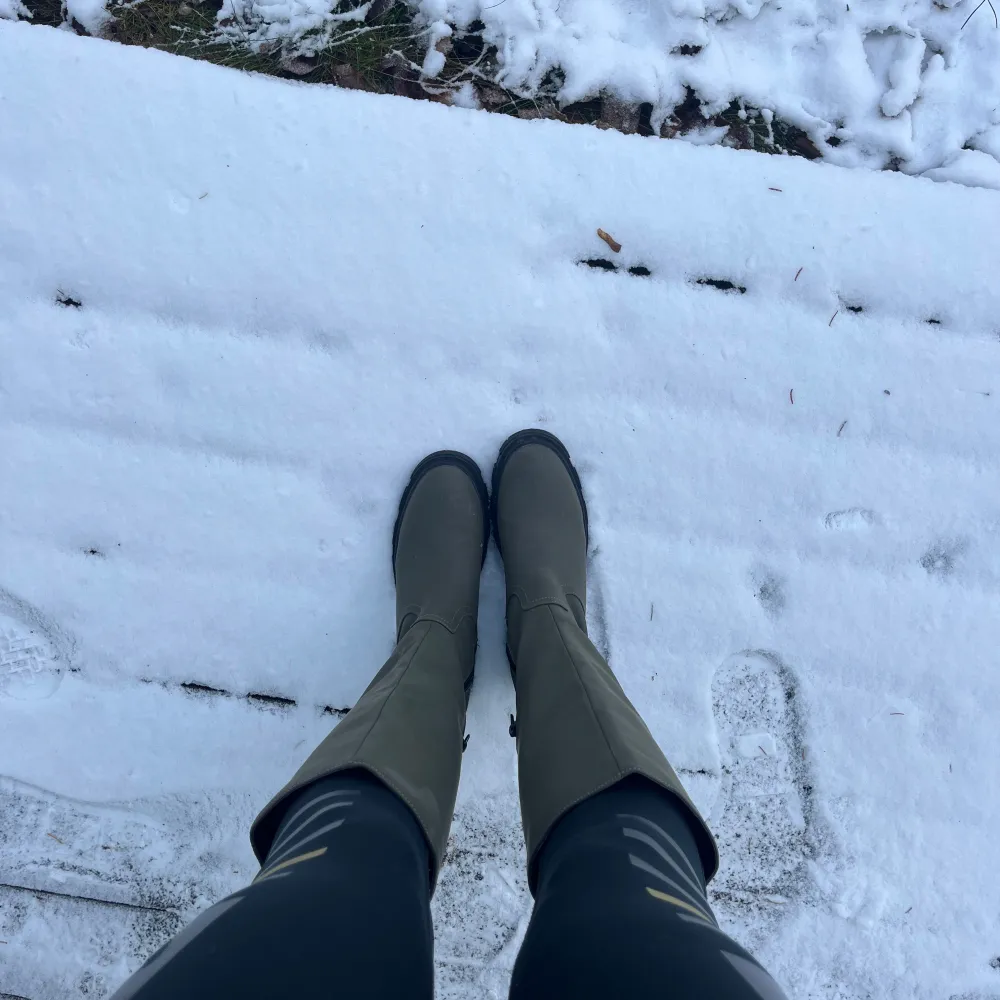 Säljer ett par gröna stövlar perfekta för vintern. De har en robust sula som ger bra grepp i snön och en dragkedja på sidan för enkel på- och avtagning. Stövlarna är i mycket bra skick och passar perfekt för kalla dagar.. Skor.