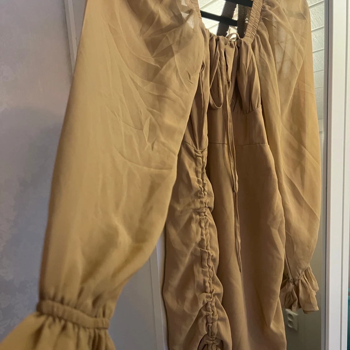 Beige klänning med volangdetaljer - 90