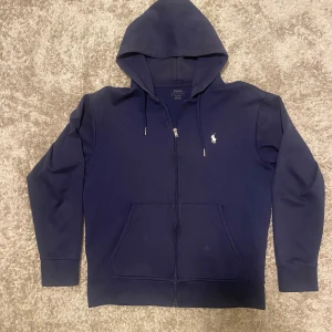 Ralph lauren kofta  - Säljer en marinblå Ralph Lauren kofta i storlek M som jag köpte från Care of Carl för några år sedan. Den är i mycket bra skick och håller den höga kvalitet som Ralph Lauren är kända för. Nypris var 2000 kr, men jag säljer den för endast 1049 kr. Vid snabb affär kan priset diskuteras.  Hör av dig om du är intresserad!🙌🙏🔥