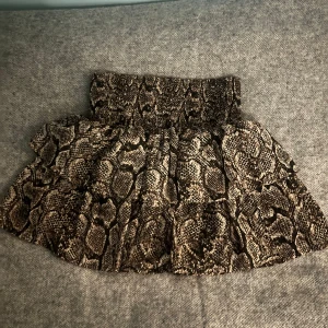 Ormmönstrad kjol - Säljer en supercool ormmönstrad kjol i kort modell. Perfekt för en utekväll eller fest! Sjukt snygg till nude färgat eller vit/svart, särskilt på sommaren när man e tanned rekommenderar starkt!!!! Ser liten ut men passar alla storlekar eftersom stt midjan e så elastisk.