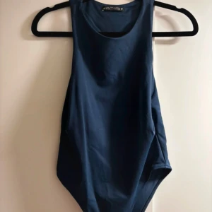 Blå ärmlös topp från Zara - Snygg blå ärmlös topp från Zara i mjukt material. Perfekt för sommardagar eller som ett lager under en jacka. Enkel och stilren design som passar till det mesta. Ett måste i garderoben!
