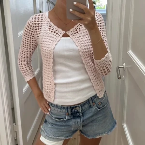 Rosa virkad bolerotopp - Säljer en superfin rosa virkad bolerotopp med trekvartsärm. Perfekt för sommarens alla tillfällen! Den är lätt och luftig, vilket gör den idealisk att bära över ett linne eller klänning. Toppen har en söt och romantisk stil som passar både till vardags och fest. 🩷
