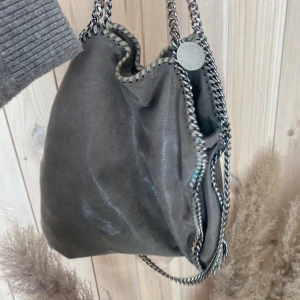 Stella McCartney väska - SUPERSNYGG, är ganska sliten❣️ därav priset!! Kedjorna högst upp har rostat, inuti(visas på bilderna) är Stella lite avskrapat och är lite grön färg på vissa ställen men inget man ser alls iprincip 💕(insidan och jätte lite på baksidan)