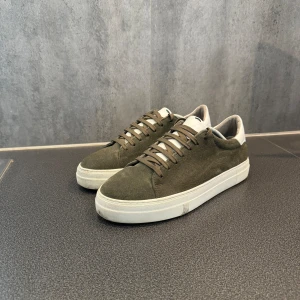 Olivgröna sneakers i mocka - Säljer ett par stilrena olivgröna sneakers i mocka med vit sula och detaljer. Det är ett par sneaky steve i väldigt bra skick med rak knytning. Pris kan diskuteras🙌🏽