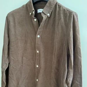  Samsøe Samsøe långärmad skjorta - Brun långärmad skjorta i storlek M från Samsøe Samsøe (Liam BX shirt). Använd endast ett par gånger och är i väldigt bra skick. Nypris ligger på 1000 kr. 