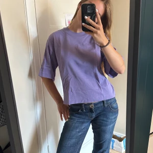 Oanvänd lila t-shirt från & Other stories - Säljer den här väldigt coola lila tröjan från & Other stories med trekvartslånga ärmar. Helt oanvänd med prislappen kvar. Superfin färg💓💓