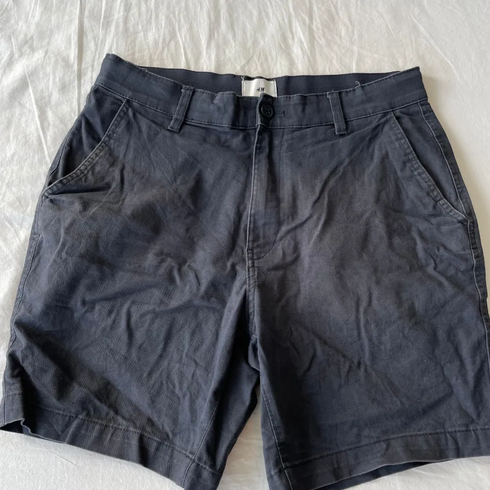 Säljer ett par mörkblå shorts från H&M i storlek S. De är i okej skick, lite missförgadd och har en klassisk design med två sidofickor och två bakfickor. Perfekta för sommaren eller våren! Frågor? Skriv!. Shorts.