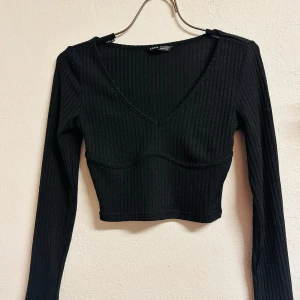 Ny sexig ribbad topp från Shein Stl 34 Crop Croptop Oanvänd  - Säljer en ny snygg svart ribbad topp från Shein i storlek XS. Toppen har en v-ringad design och är croppad med långa ärmar. Fina detaljer som markerar bysten. Bredd 38 cm, längd 47 cm. Stl 34. Perfekt för både vardag och fest! Jag ger bundlerabatt. 