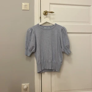 Ljusblå tröja från Minus - Säljer en superfin ljusblå tröja från Minus. Den har korta puffärmar och en ribbad kant vid halsen och ärmsluten. Perfekt för vår och sommar! 💙