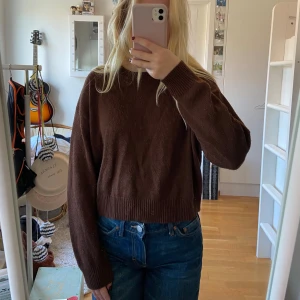 Brun stickad tröja - Säljer en mysig brun stickad tröja. Den har en normal passform med långa ärmar och ribbade muddar vid ärmslut och nederkant. Perfekt för höst och vinter! Lite nopprig annars i bra skick!