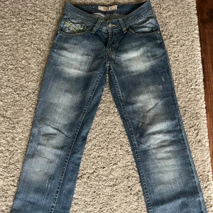 Lågmidjade bootcut jeans - Ett par jättefina vintage lågmidjade bootcut jeans med mönstrade fickor💓