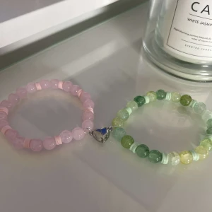 Två färgglada pärlarmband - Säljer två superfina pärlarmband! Ett är rosa med ljusrosa och genomskinliga pärlor, och det andra är grönt med olika nyanser av gröna och gula pärlor. 💖💚