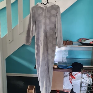 Onepiece för barn 140/146 - Måttligt använd onepiece. Supermysig nu inför hösten. Små öron finns på luvan.  Katt finns i hemmet. 