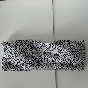 Prickig tubtopp - Säljer en superfin svartvit prickig bikiniöverdel.  Den är axelbandslös och har en tight passform. Oanvänd 
