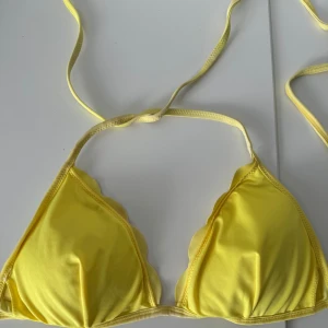 Gul bikiniöverdel - Säljer en superfin gul bikiniöverdel i trekantsmodell. Perfekt för sommaren med knytband som gör att den sitter bra! . Färgen är riktigt härlig! 