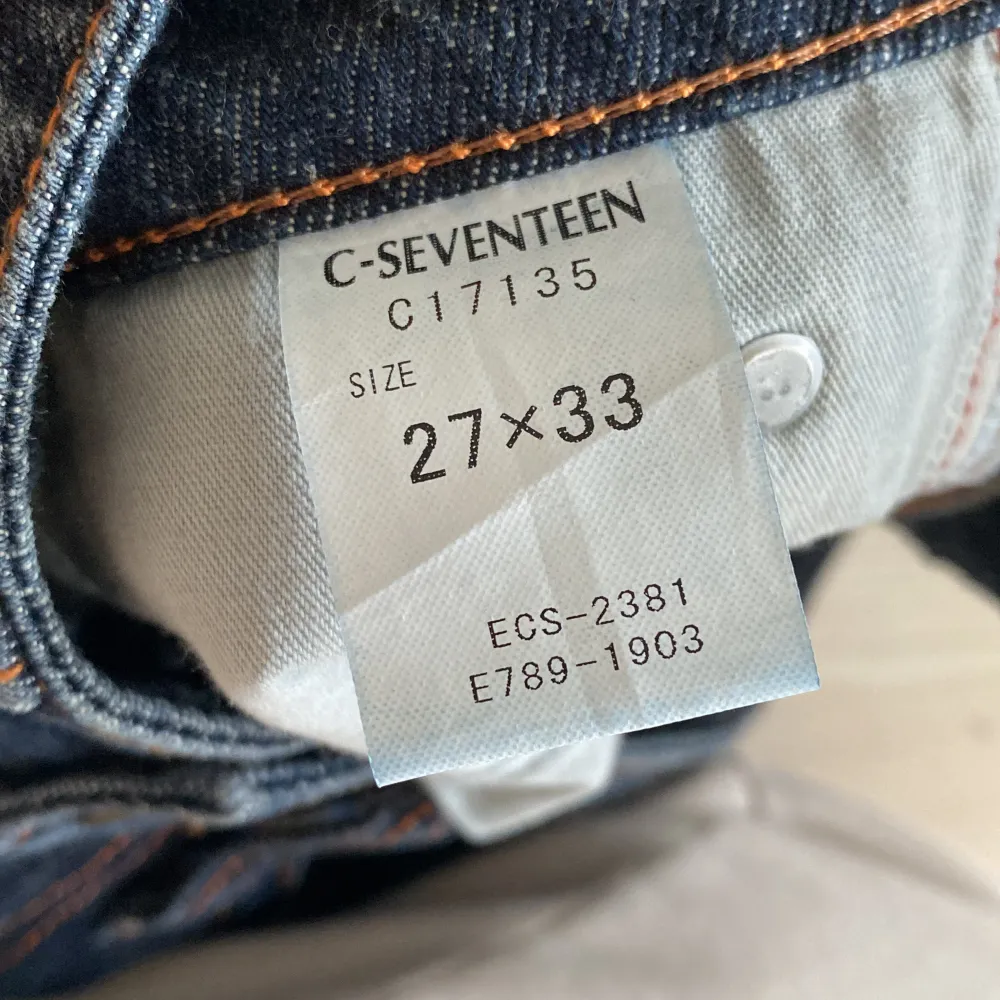 Säljer ett par snygga mörkblå bootcut jeans från C-Seventeen. De har en klassisk femficksdesign med orange sömmar som ger en cool kontrast. Jeansen är i storlek 27x33 och passar perfekt för en avslappnad men stilren look. . Jeans & Byxor.