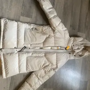 En beige parajumpers jacka i beige för dam, äkta, finns QR kod på. Storlek XS men lite liten i storleken så räkna med XXS.  Lite smutsig vid armarna och fickorna men invet jag försökt tvätta bort än. Köpt för ca 8000, säljer för 3500, pris kan sänkas