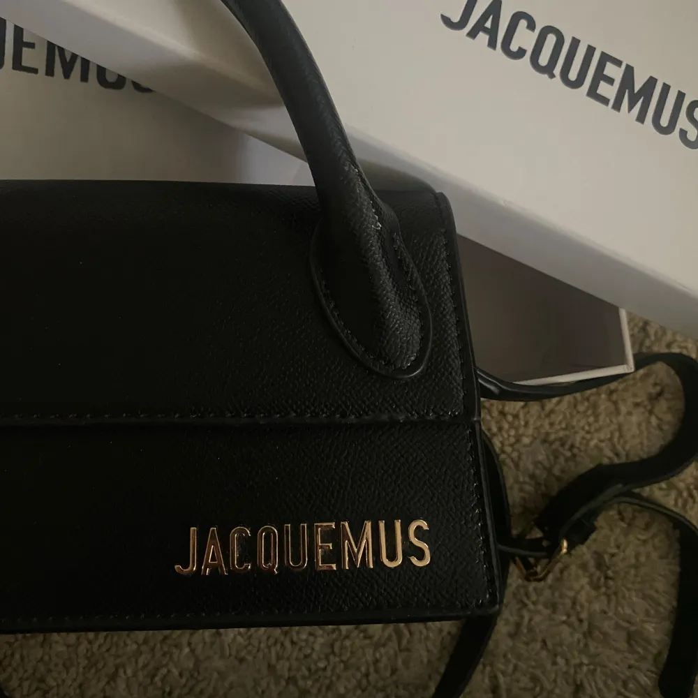 Säljer en superfin svart handväska från Jacquemus. Den är i skinn och har en stilren design med ett handtag och en avtagbar axelrem. Perfekt för både vardag  och finare tillfällen💞💞💓 Köpt på en secondhandbutik i Göteborg så har inte något äkthetsbevi. Väskor.