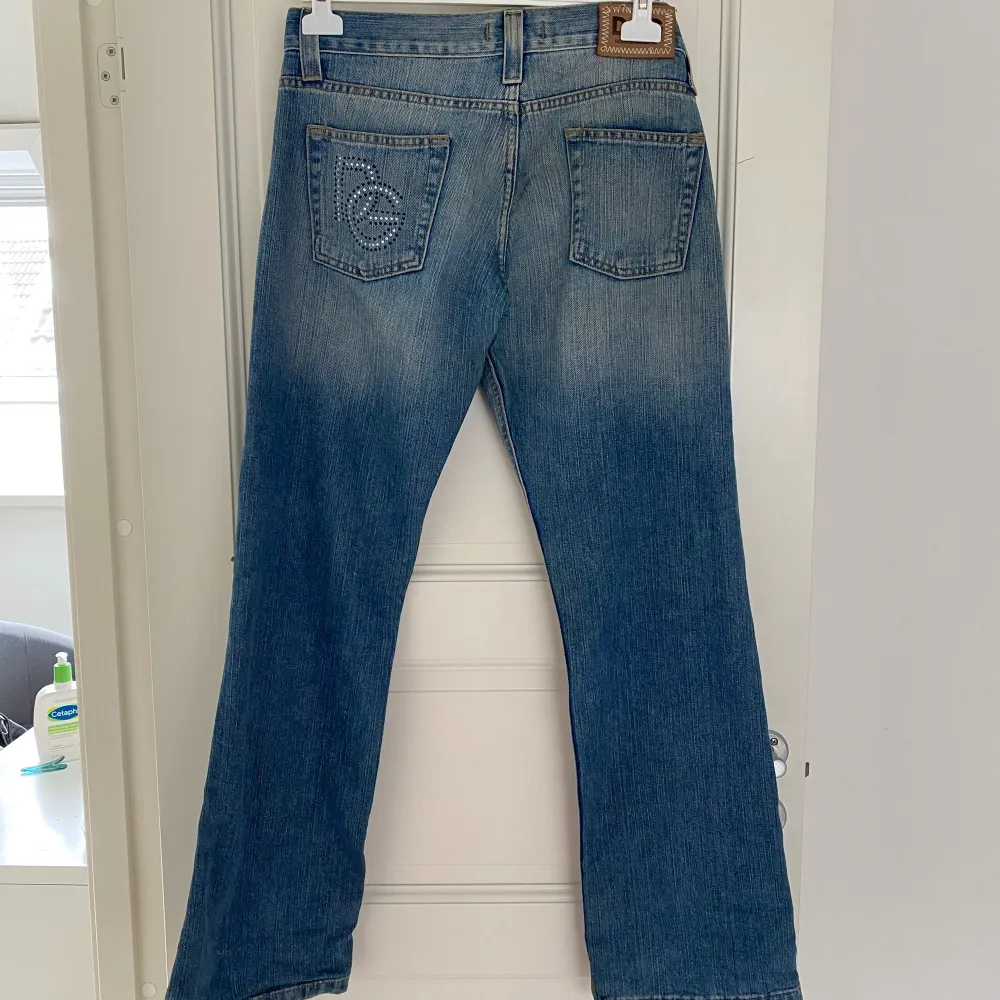 Mina älsklings Dolce & Gabbana jeans är nu till salu! Perfekt passform på mig som bär storlek 38, 177 cm lång. Lite utsvängda och lågmidjade. Vackra detaljer med glitter korn på både framsidan och baksidan, några slitningar på låren. Inga defekter ❤️‍🔥. Jeans & Byxor.