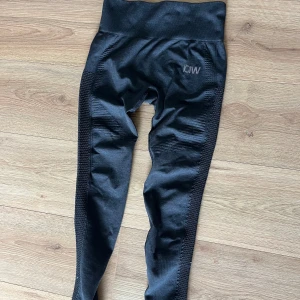 Svarta träningstights från ICANIWILL - Säljer ett par svarta leggings från ICANIWILL. De är högmidjade och har en tight passform, perfekt för träning. Materialet är stretchigt och bekvämt, med snygga detaljer längs sidorna.