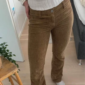 Bruna manchesterbyxor - Säljer ett par snygga bruna manchesterbyxor. De är högmidjade och har en straight passform. Perfekta för höst och vinter, och de ger en riktigt skön retrovibe. Byxorna har en knapp och dragkedja framtill.