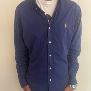 Ralph lauren skjorta strl-M - Hej! Jag säljer nu min snygga Ralph lauren skjorta i Färgen marinblå. Den är i bra skick och väldigt snygg och stilren. Vid fler frågor och funderingar är det bara att höra av sig!