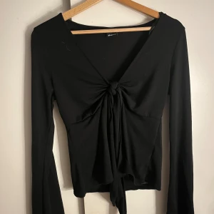 Jättefin svart topp från Gina tricot!💗 - Säljer denna jätte gulliga svarta tröjan som man knyter där fram!storlek M och oanvänd då jag inte gillade hur den satt på mig. Jättefint skick inga defekter någonstans. Köptes för 399 men lägre pris pga rea.Hör av er om ni har frågor eller liknande💗