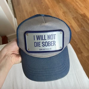 Keps - Keps från john hatter & co, lite solblekt.