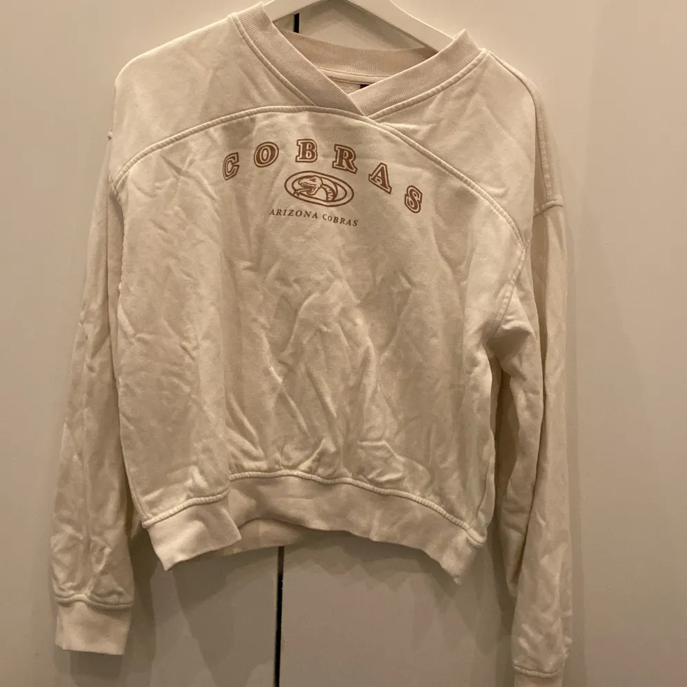 Säljer en vit sweatshirt från H&M Divided med trycket 'Cobras Arizona Cobras' på framsidan. Tröjan har en avslappnad passform och är perfekt för en casual look. Den är långärmad och har en mjuk insida för extra komfort. Perfekt för höst och vinter!. Tröjor & Koftor.