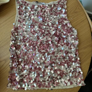 Paljettopp  - Fin paljetttopp i rosa/silver från Vero Mont. Passar nog XS-L beroende på hur du vill att den ska sitta. Jag är normalt en S/M och den passar mig. 