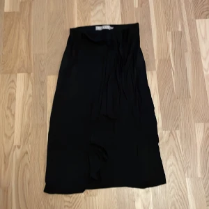 Svart kjol från Pieces - Säljer en stilren svart kjol från Pieces i storlek S. Kjolen har en enkel och elegant design, perfekt för både vardag och fest. Den är gjord i ett mjukt och bekvämt material som faller fint. finns ej några defekter