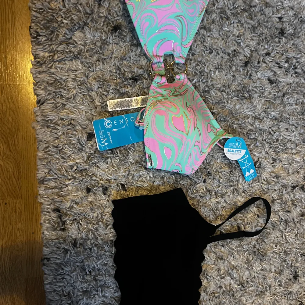 Säljer en superfin bikini från Censor i storlek M. Överdelen har ett coolt mönster i rosa, grönt och blått med en snygg knytning framtill. Perfekt för sommarens alla badäventyr! den andra är en stilren svart bikini topp!. Övrigt.