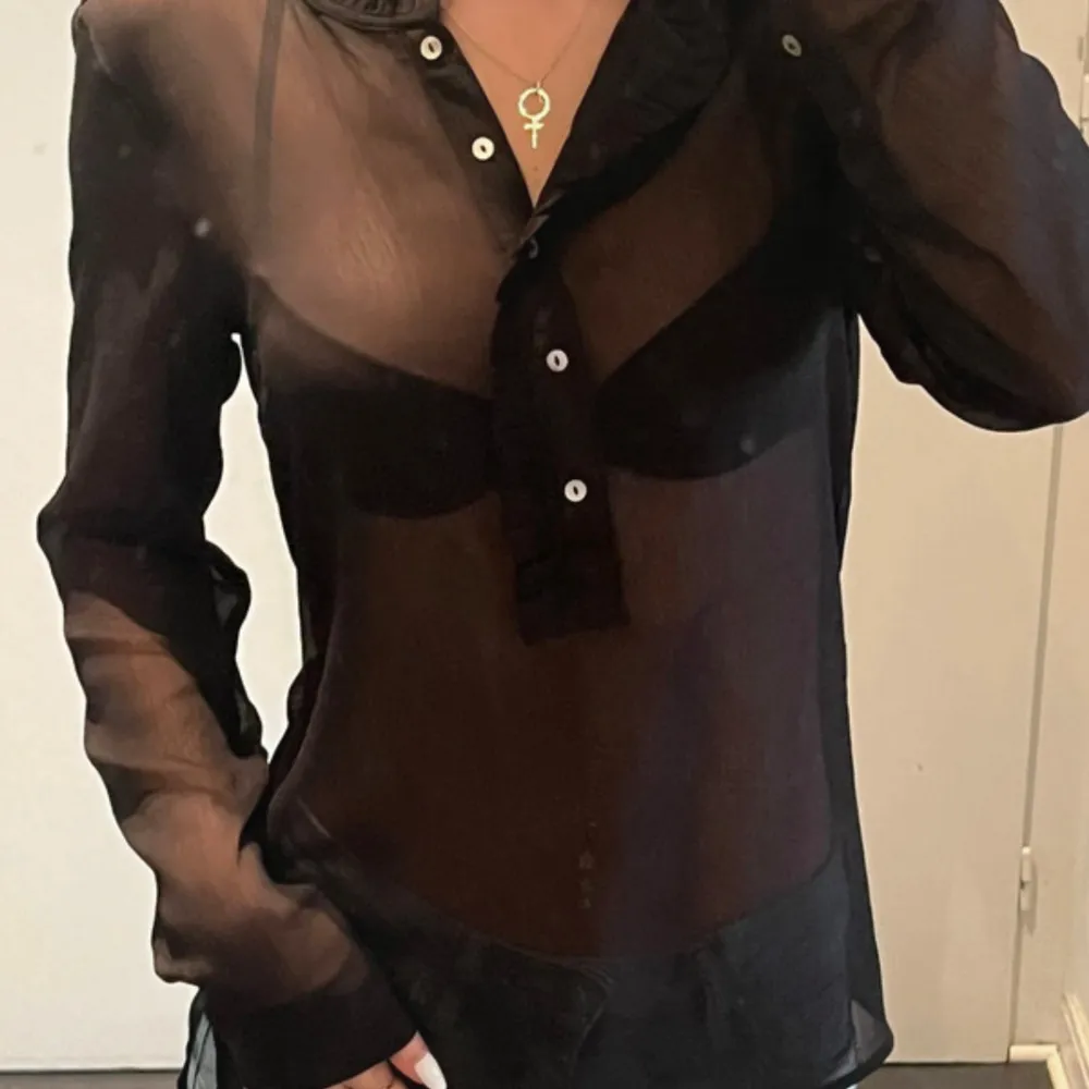 Svart genomskinlig blus från H&M. Använd ett fåtal gånger.. Puserot.