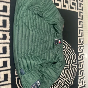 Grön dunjacka från Tommy Hilfiger - Säljer en snygg Tommy Hilfinger väst grön.
