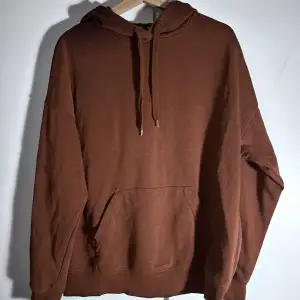 Brun Hoodie. Lite nopprig och har ett litet hål vid fickan, det ser lila ut på bilden men det är den inte i verkligheten.  