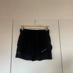 Säljer ett par svarta shorts från Swedemount. De har en elastisk midja och är perfekta för träning. Det finns en liten svensk flagga på sidan och Swedemount-loggan tryckt på framsidan. Shortsen är i bra skick då dom aldrig är använda!💕