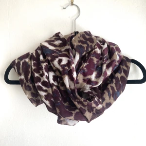 Leopardmönstrad tubhalsduk, scarf, sjal, mörkröd, burgundy, brun, beige, blå, tunn, djurmönstrad - Leopardmönstrad tunn vävd sjal i tubmodell, finns några dragna trådar. Bredd: 77 cm, höjd: 97 cm.