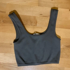 Grå ribbad linnetopp - Säljer en snygg grå ribbad linnetopp i nyskick. Perfekt för både vardag och träning. Toppen har en tight passform och är ärmlös