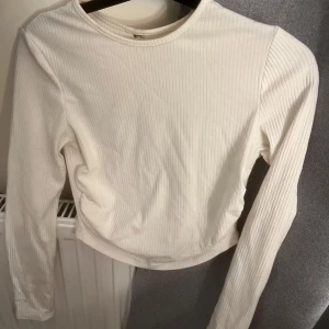 Topp - En kroppad vit ribbad långärmad tröja