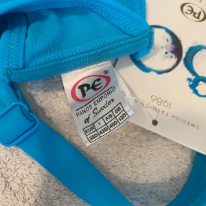 Blå bikiniöverdel från Panos Emporio - Säljer en snygg blå bikiniöverdel från Panos Emporio. Den har justerbara axelband och en bekväm passform. Perfekt för sommarens alla badäventyr! 💙