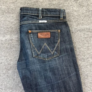 Wrangler-jeans  - Säljer ett par lågmidjade jeans från wrangler då de är lite små för mig. De är pyttelite slitna (sista bilden) men annars i mycket bra skick. Storlek W30 L34💗    Midjemått: ca 40 cm, Grenmått: ca 20 cm, Innerbenslängd: ca 83 cm 