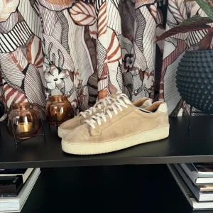 Beige sneakers i mocka - Säljer ett par snygga beige sneakers i mocka. Skorna är i bra skick och märket är tiger of Sweden. Pris kan diskuteras!