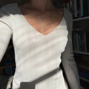 Ribbad krämvit topp - Jättefin ribbad topp med slits vid händerna och höften. Passar som s/xs. V-ringad och framhäver former jättefint!!!🍁❤️