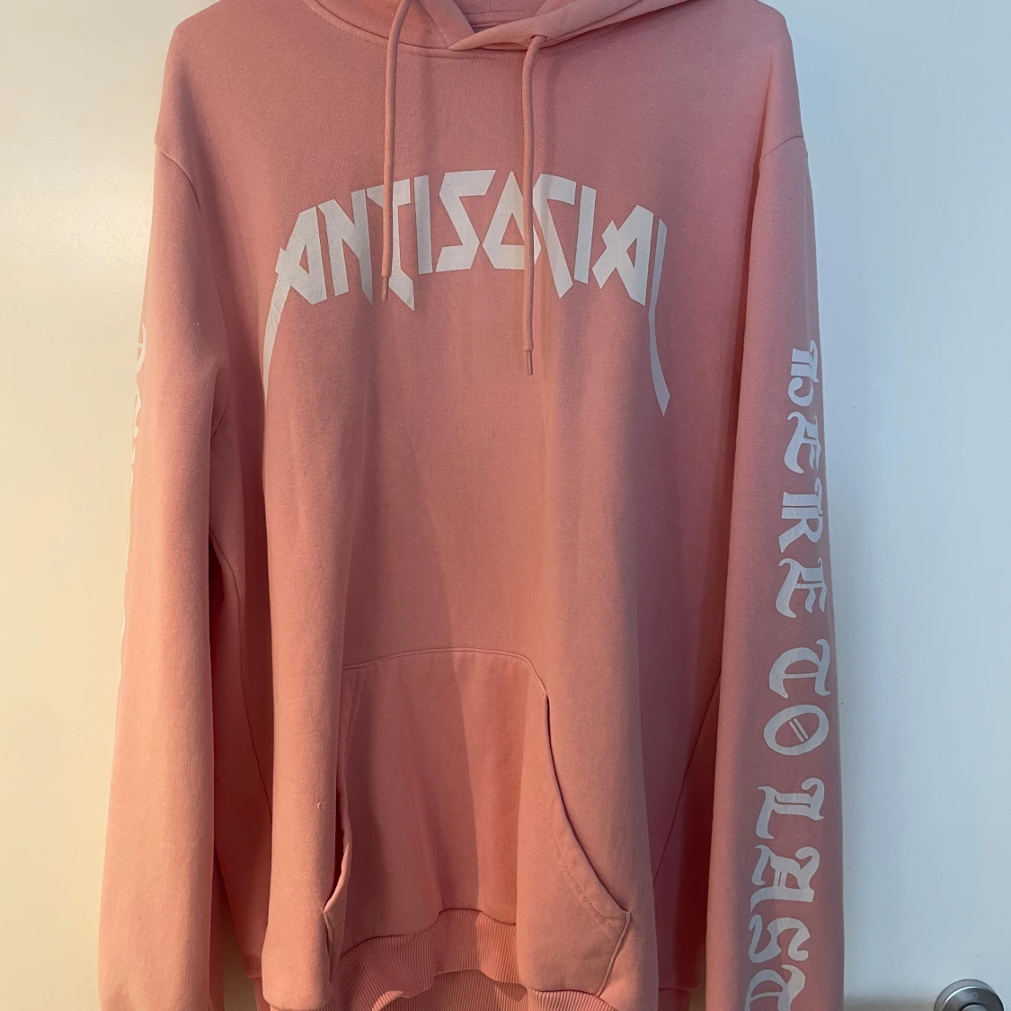 Rosa hoodie med vit text på