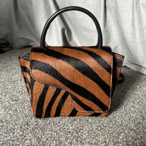 Liten Atp väska  - En jätte cool och unik ATP väska i den minsta storleken som precis har utgått från sortimentet. Det är använd ca 5 gånger så inga defekter eller liknade. Den ser ut som ny🐆🫶🏼🦓 köpte för 3700kr på Atps hemsida🫶🏼 pris kan diskuteras! Tote bag medföljer! 