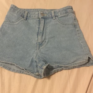  Ett par ljusblå jeans shorts från H&M -  Säljer ett par ljusblå jeans shorts från H&M i storlek 32