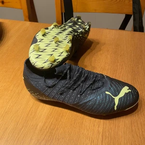 Svarta fotbollsskor från Puma - Snygga svarta fotbollsskor från Puma med limegröna detaljer och snörning. Skorna har en mönstrad sula för bra grepp på planen och är tillverkade i syntetmaterial. Använd 2 gånger, storlek 42-43, Jätte bra skick och pris för dessa 